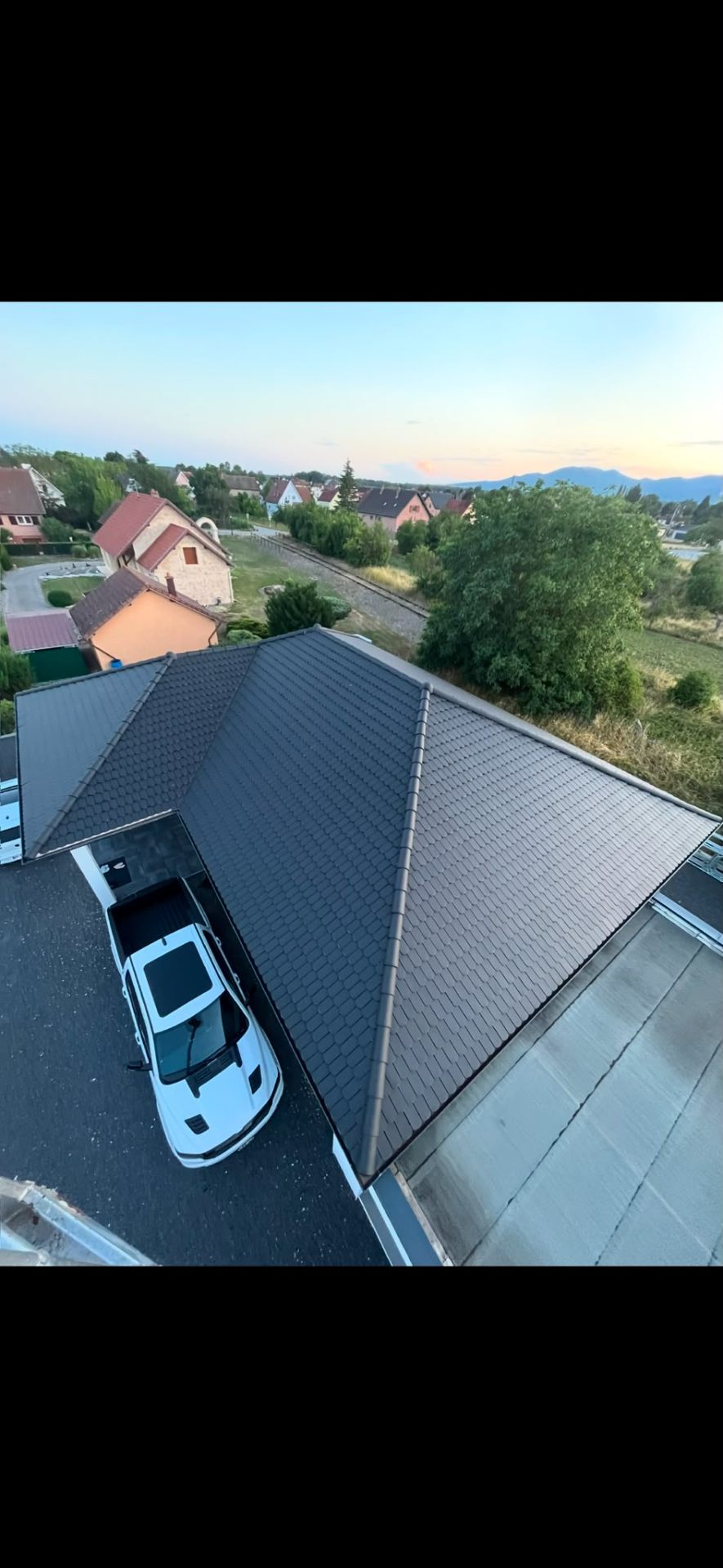 Vue aérienne d'une toiture rénovée en ardoise avec zinguerie neuve dans le Haut-Rhin